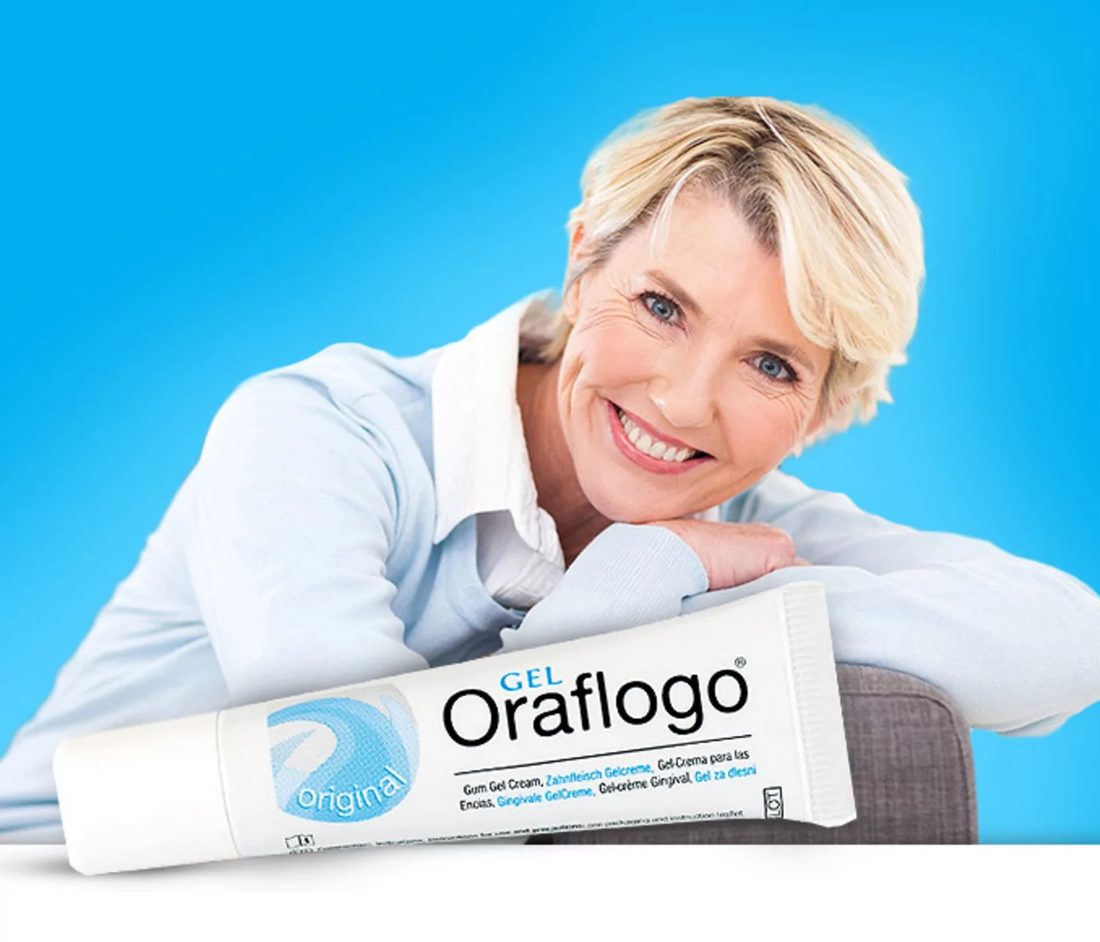 A smiling woman resting beside a tube of Oraflogo Gel